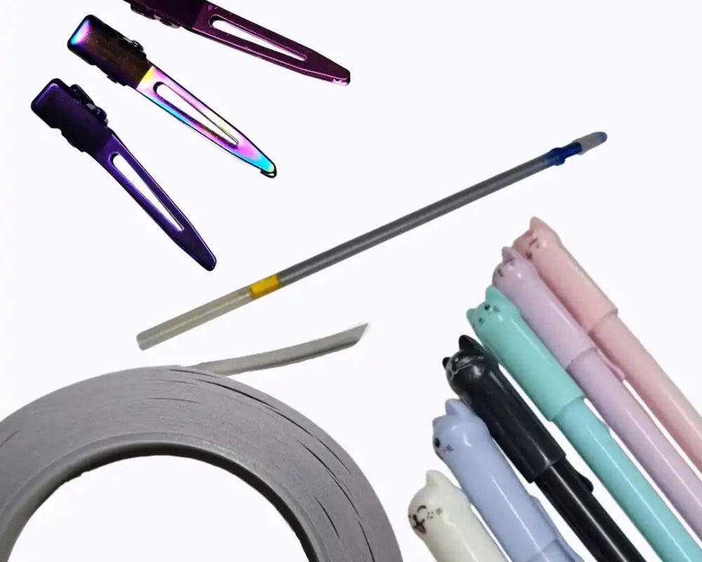 Eine Sammlung von Haarklammern, Kugelschreiberfüllungen und Katzen-Motiv-Stiften mit einem Roll Klebeband.